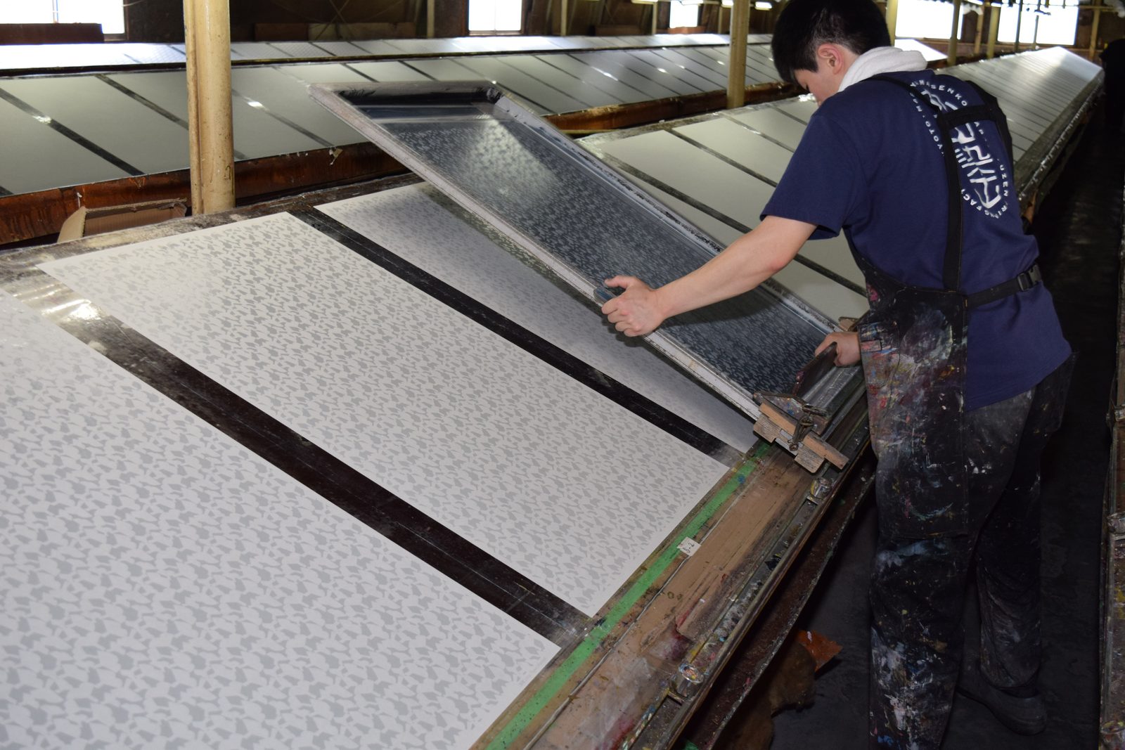 A craftsman lifting the screen from washi